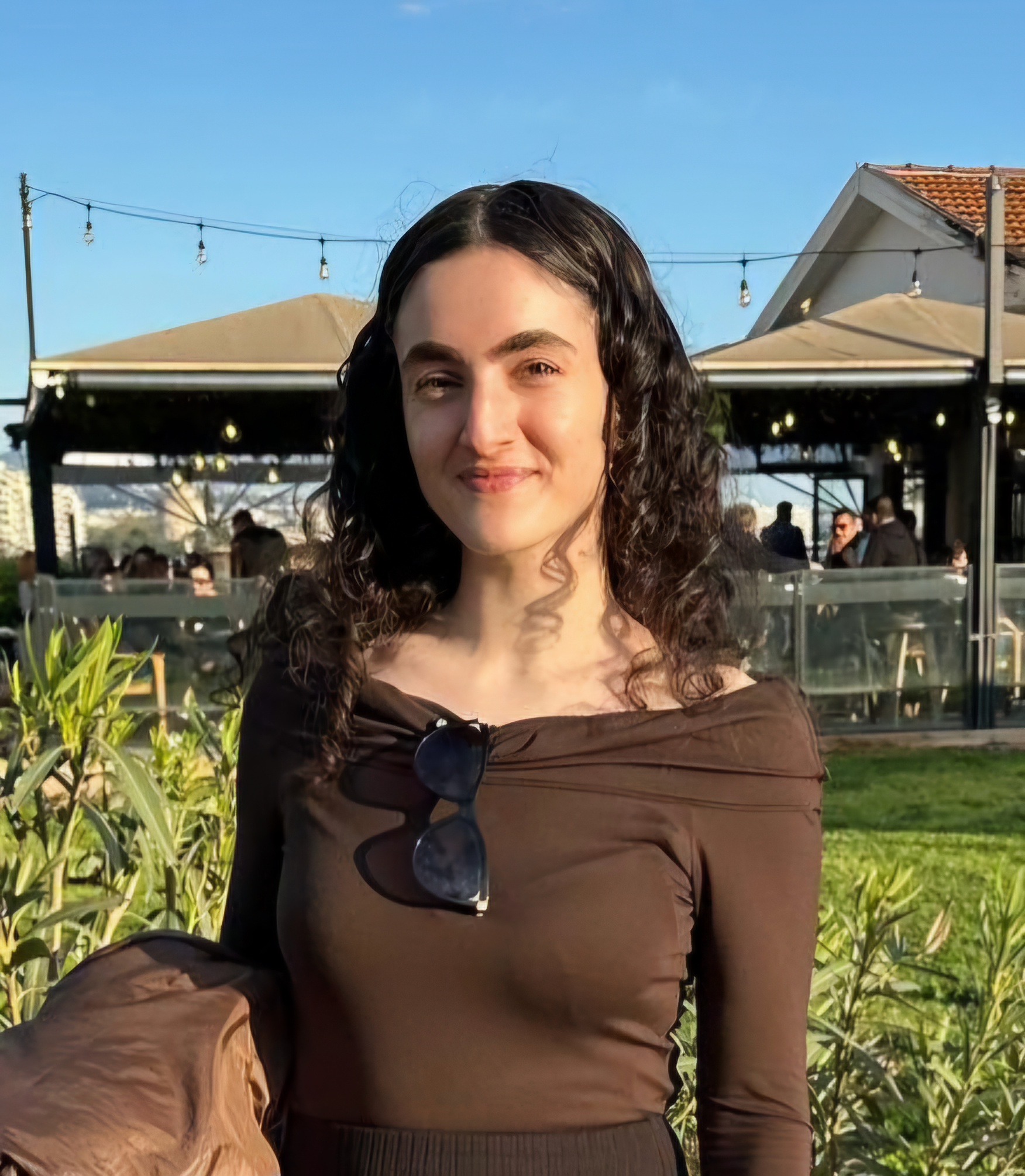 Anastasia smiling outdoors in a sunny setting